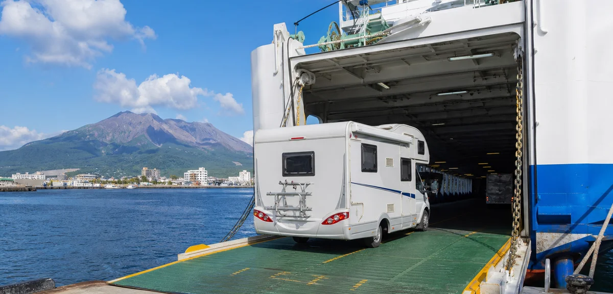 フェリーの車両甲板に乗り込むキャンピングカー、錦江湾の港、桜島が見える晴れた午後、写実的、文字なし